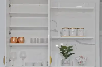 a white shelf with cups and a plant in it at Chic 3BR-4BD-3Bath Oasis with Backyard Near NYC in Jersey City