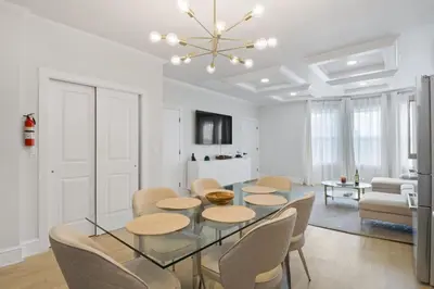 a dining room with a glass table and chairs at Elegant 2BR-2BA Spacious Escape with Rooftop Near NYC in Jersey City