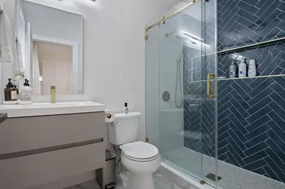 a bathroom with a toilet and a glass shower at Elegant 2BR-2BA Spacious Escape with Rooftop Near NYC in Jersey City