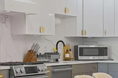 a kitchen with white cabinets and a stove and a microwave at Elegant 2BR-2BA Spacious Escape with Rooftop Near NYC in Jersey City