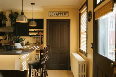 a kitchen with a door and a counter with stools at The Ashfield House - Close to Downtown Lancaster in Lancaster