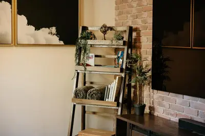 a shelf with books on it next to a brick wall at The Ashfield House - Close to Downtown Lancaster in Lancaster