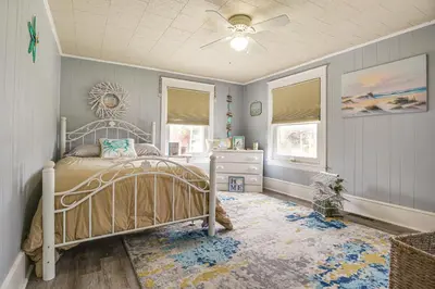 a bedroom with a bed and a dresser and windows at Close to Venues and Fairgrounds! York Area Home in Red Lion