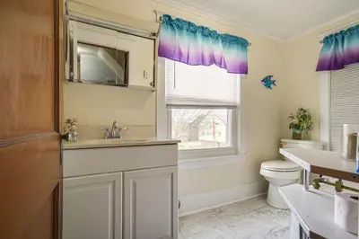a bathroom with a sink and a toilet and a window at Close to Venues and Fairgrounds! York Area Home in Red Lion