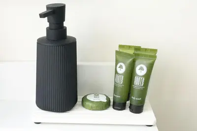 a bottle of hair products and a watermelon on a shelf at Excellence by Urooms Apartments Near NYC and Newark Airport with Parking in Elizabeth