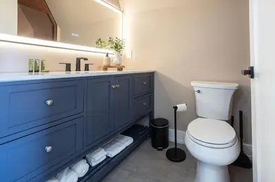 a bathroom with a blue vanity and a toilet at Excellence by Urooms Apartments Near NYC and Newark Airport with Parking in Elizabeth