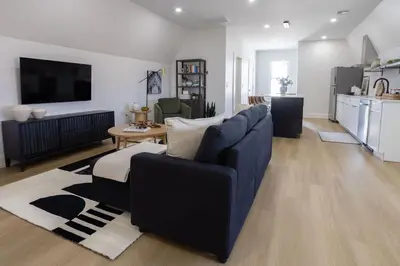 a living room with a blue couch and a kitchen at Excellence by Urooms Apartments Near NYC and Newark Airport with Parking in Elizabeth
