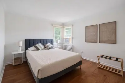 a white bedroom with a bed and a window at Lakefront House 30 Min to NYC & MetLife Stadium