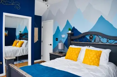 a bedroom with two beds and a blue wall at LUX Poconos Home MINS to Lehigh Valley Hosp in Pocono Summit