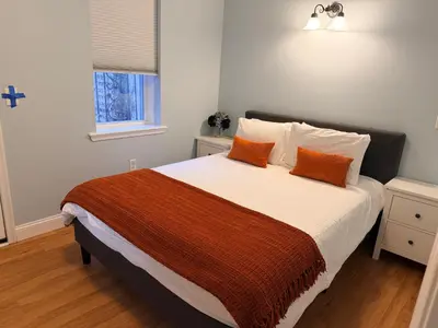a bedroom with a large bed with orange pillows at Spacious one bedroom Apartment in University City near Drexel&UPenn in Philadelphia