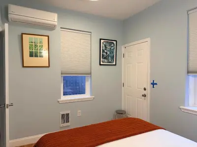 a bedroom with a bed and two windows at Spacious one bedroom Apartment in University City near Drexel&UPenn in Philadelphia