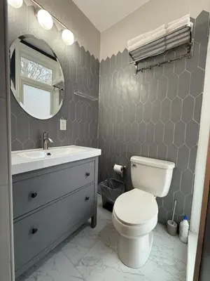 a bathroom with a toilet and a sink and a mirror at Spacious one bedroom Apartment in University City near Drexel&UPenn in Philadelphia