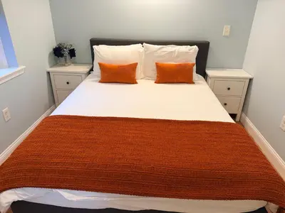 a bed with two orange pillows on top of it at Spacious one bedroom Apartment in University City near Drexel&UPenn in Philadelphia