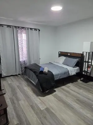 a bedroom with a bed and a wooden floor at FNR Suites, Washington Ave, Endicott, NY in Endicott