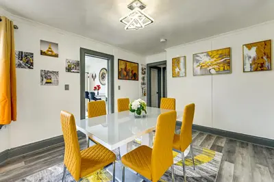 a dining room with a glass table and yellow chairs at Walk to Shops, Parks and Restaurants Teaneck Escape in Teaneck