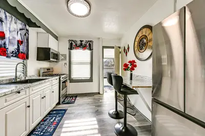 a kitchen with white cabinets and a refrigerator at Walk to Shops, Parks and Restaurants Teaneck Escape in Teaneck