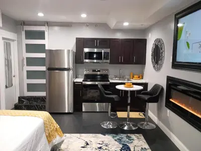 a kitchen with a bed and a tv in a room at Nectar of the Gardens in Newark