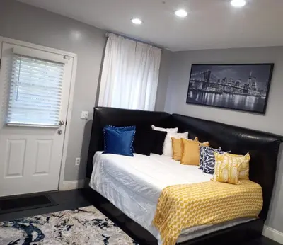 a bedroom with a large bed with blue and yellow pillows at Nectar of the Gardens in Newark