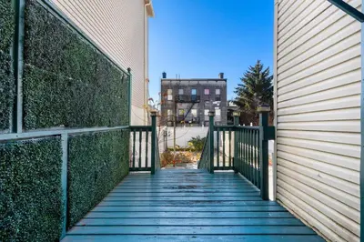 a walkway between a building and a fence at Queen Bedroom w Ensuite Bathroom - Mins from NYC in Jersey City