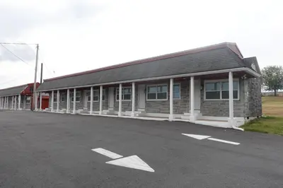 a building with a parking lot in front of it at Freedom INN Motel in Grantville
