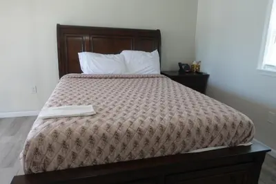 a bed with a brown comforter in a bedroom at Freedom INN Motel in Grantville