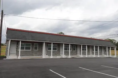 a building with a parking lot in front of it at Freedom INN Motel in Grantville