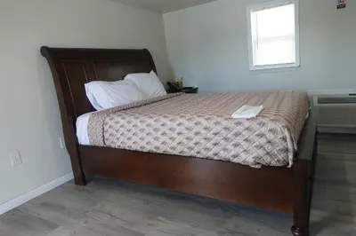 a bed with a wooden frame in a bedroom at Freedom INN Motel in Grantville