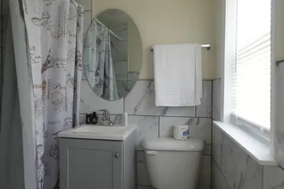 a bathroom with a toilet and a sink and a mirror at Freedom INN Motel in Grantville