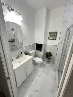 a white bathroom with a toilet and a sink at Beautiful and comfortable room, close to New York Hermosa y cómoda habitación, cerca a New York in West New York