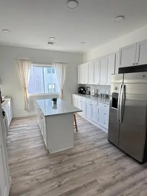 a kitchen with white cabinets and a refrigerator at Beautiful and comfortable room, close to New York Hermosa y cómoda habitación, cerca a New York in West New York