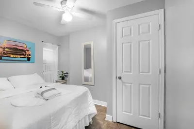 a white bedroom with a bed and a ceiling fan at Modern 2BR 10 Mins to Metro in Philadelphia