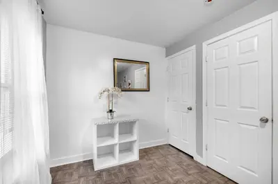 a white hallway with a white door and a mirror at Modern 2BR 10 Mins to Metro in Philadelphia
