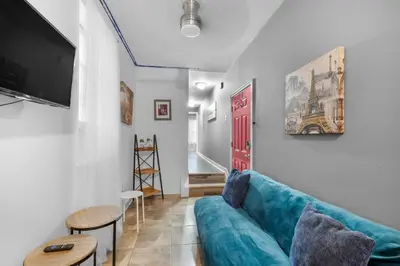 a living room with a blue couch and a red door at Modern 2BR 10 Mins to Metro in Philadelphia