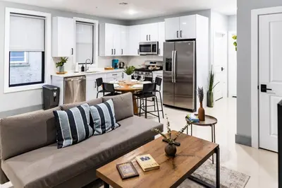a living room and kitchen with a couch and a table at City Life-2 Bedrooms-Free Indoor Parking-20minNYC in West New York