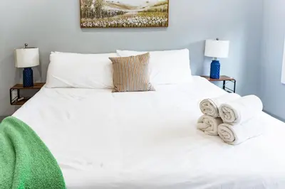 a bedroom with a white bed with towels on it at City Life-2 Bedrooms-Free Indoor Parking-20minNYC in West New York