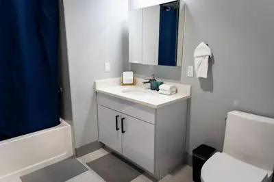a bathroom with a sink and a toilet and a mirror at City Life-2 Bedrooms-Free Indoor Parking-20minNYC in West New York