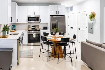 a kitchen with a wooden table and black chairs at City Life-2 Bedrooms-Free Indoor Parking-20minNYC in West New York