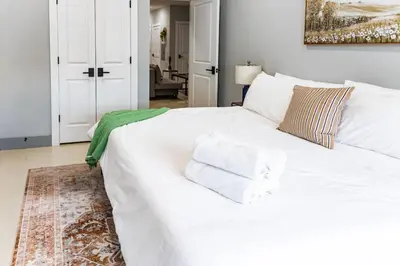 a white bed with towels on it in a bedroom at City Life-2 Bedrooms-Free Indoor Parking-20minNYC in West New York