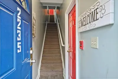 a hallway with blue and red doors and stairs at Renovated 2BR w Amenities in Philadelphia