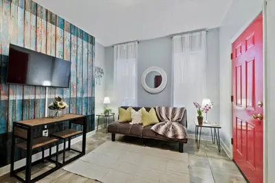 a living room with a couch and a red door at Renovated 2BR w Amenities in Philadelphia