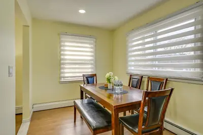 a dining room with a wooden table and chairs at Walk to Public Transit Apt Next to Lincoln Park in Jersey City