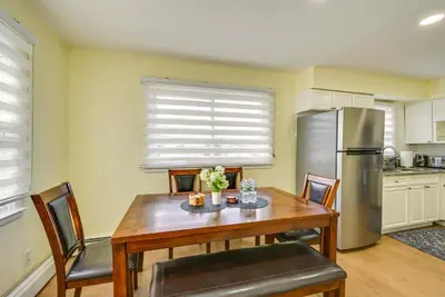 a kitchen with a wooden table and a refrigerator at Walk to Public Transit Apt Next to Lincoln Park in Jersey City