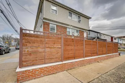 a wooden fence in front of a house at Walk to Public Transit Apt Next to Lincoln Park in Jersey City