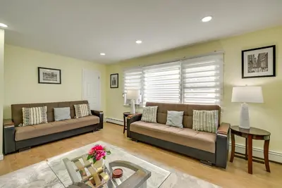 a living room with two couches and a table at Walk to Public Transit Apt Next to Lincoln Park in Jersey City