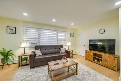 a living room with a couch and a flat screen tv at Stay and Play in Jersey City! Walk to PATH and Park in Jersey City