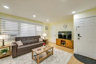 a living room with a couch and a tv at Stay and Play in Jersey City! Walk to PATH and Park in Jersey City
