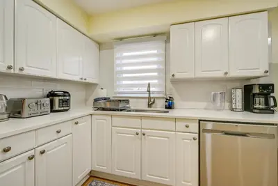 a white kitchen with white cabinets and a sink at Stay and Play in Jersey City! Walk to PATH and Park in Jersey City