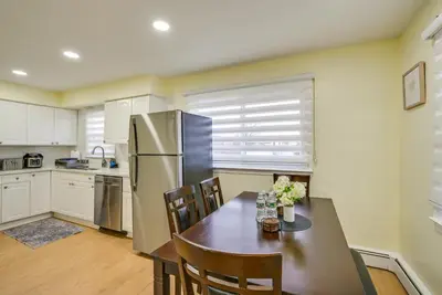 a kitchen with a dining table and a refrigerator at Stay and Play in Jersey City! Walk to PATH and Park in Jersey City
