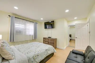 a bedroom with a bed and a couch and a television at Stay and Play in Jersey City! Walk to PATH and Park in Jersey City