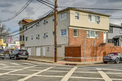 a house on a street with cars parked in front of it at Walkable Jersey City Stay Near Parks and Dining! in Jersey City